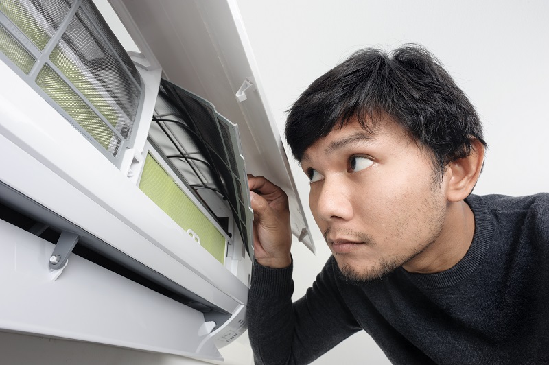 Man inspecting his HVAC system for any problems.