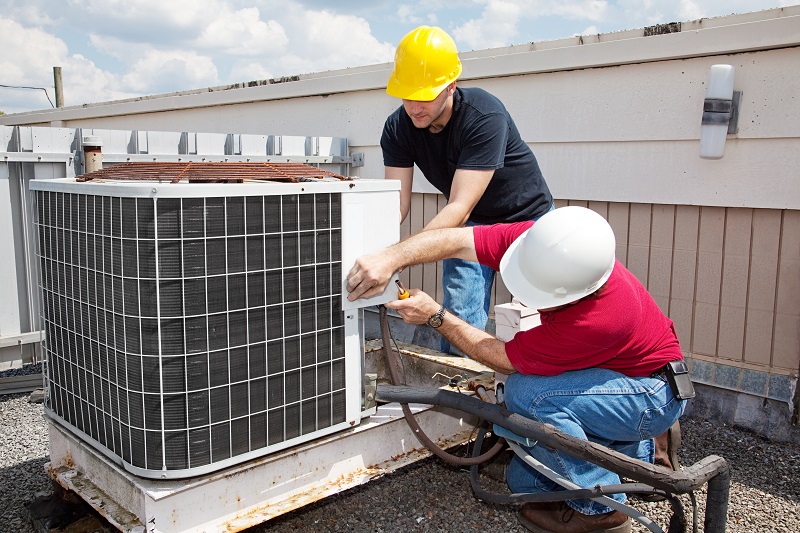 Two technicians repairing some dangerous HVAC problems.